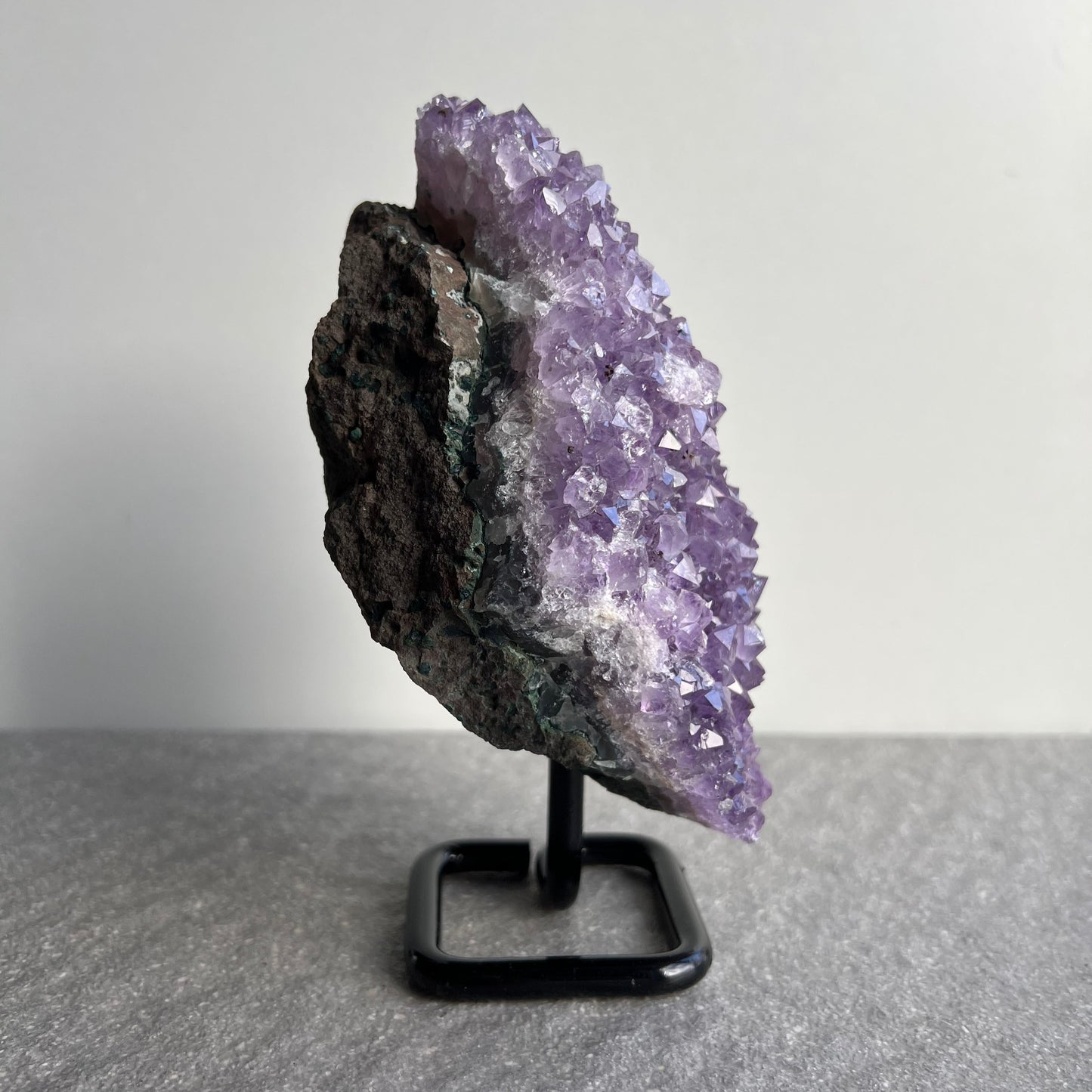 Wunderschöne dunkellila Amethyst Stufe auf schwarzem Metall-Ständer - viele kleine Kristalle - von der Seite 1