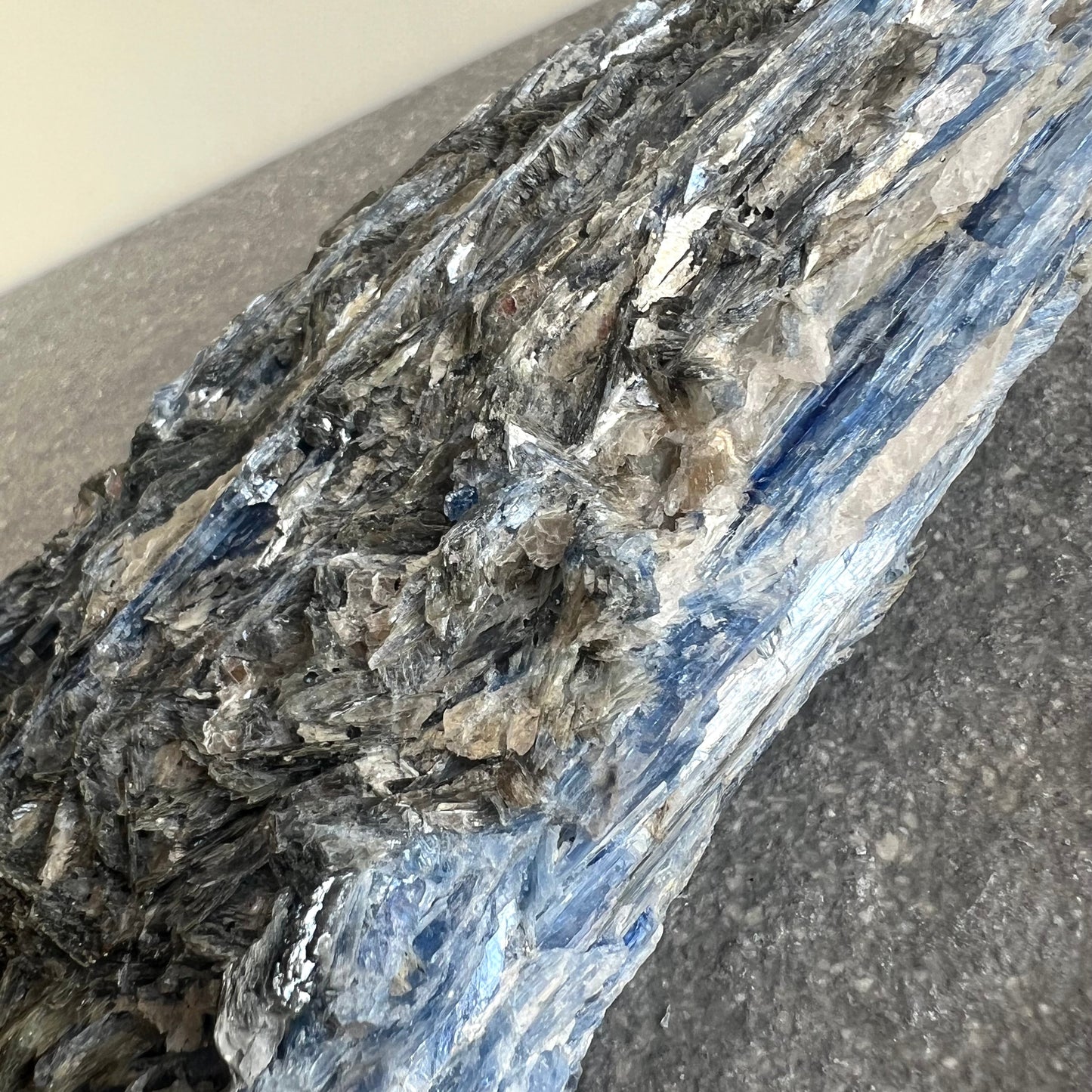 Wunderschöner blau und grau glitzernder Kyanit Rohstein - Rückseite/seitlich fotografiert - Nahaufnahme