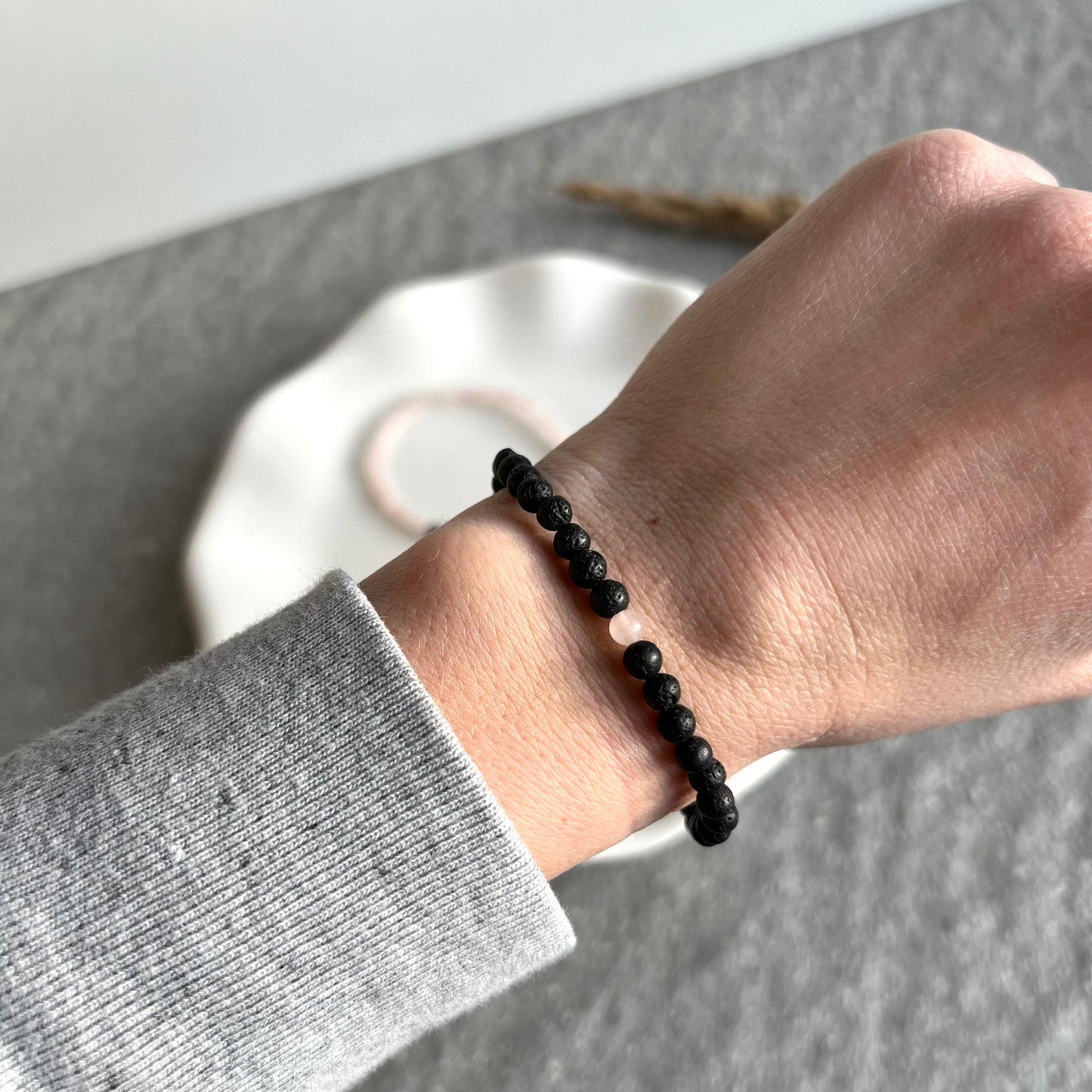 Partner-Armbandset aus 4mm Rosenquarz und Lavasteinperlen auf Tablett - Lavasteinarmband getragen