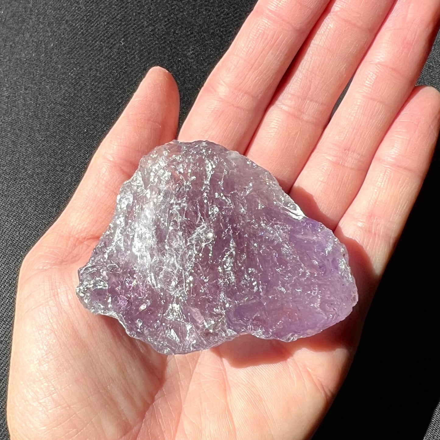 Lila Amethyst Rohstein auf Hand gehalten