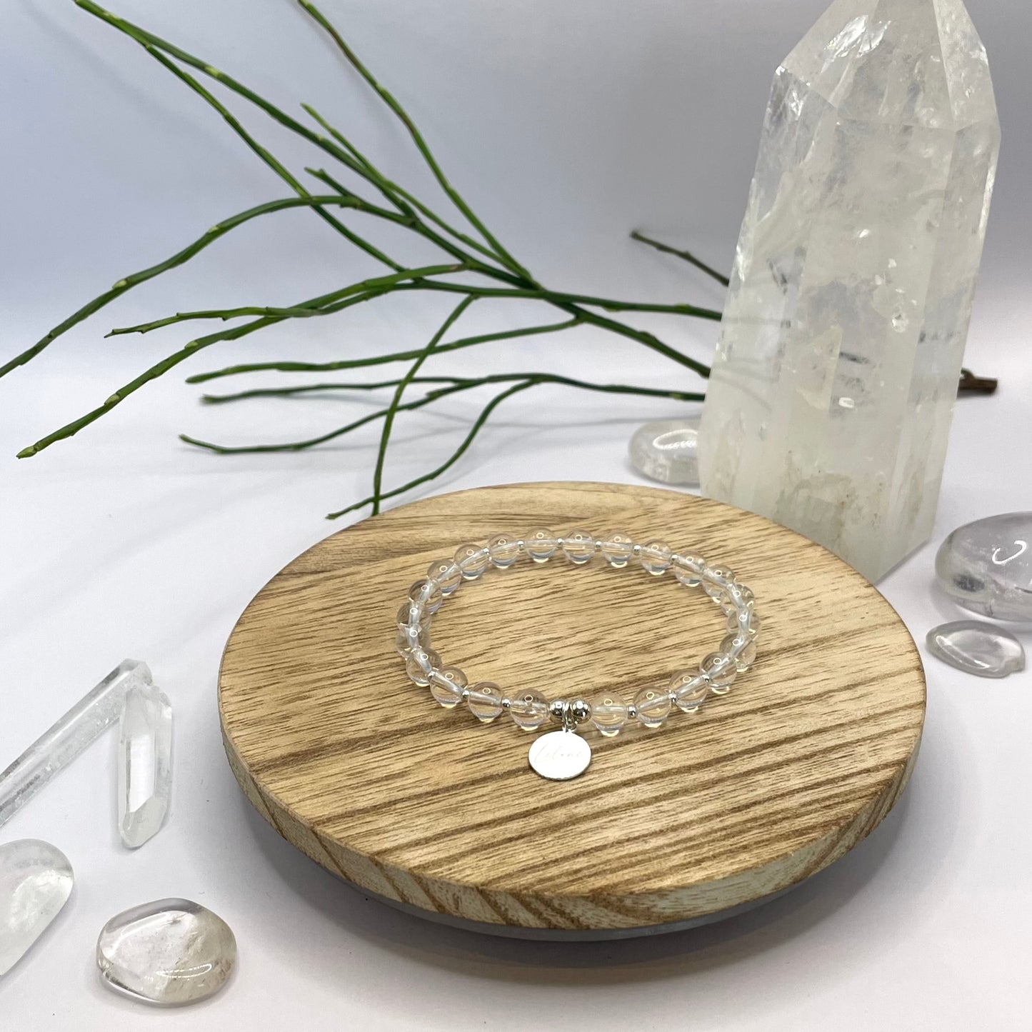 Bergkristallarmband mit Charm und Silberperlen auf Holztablett