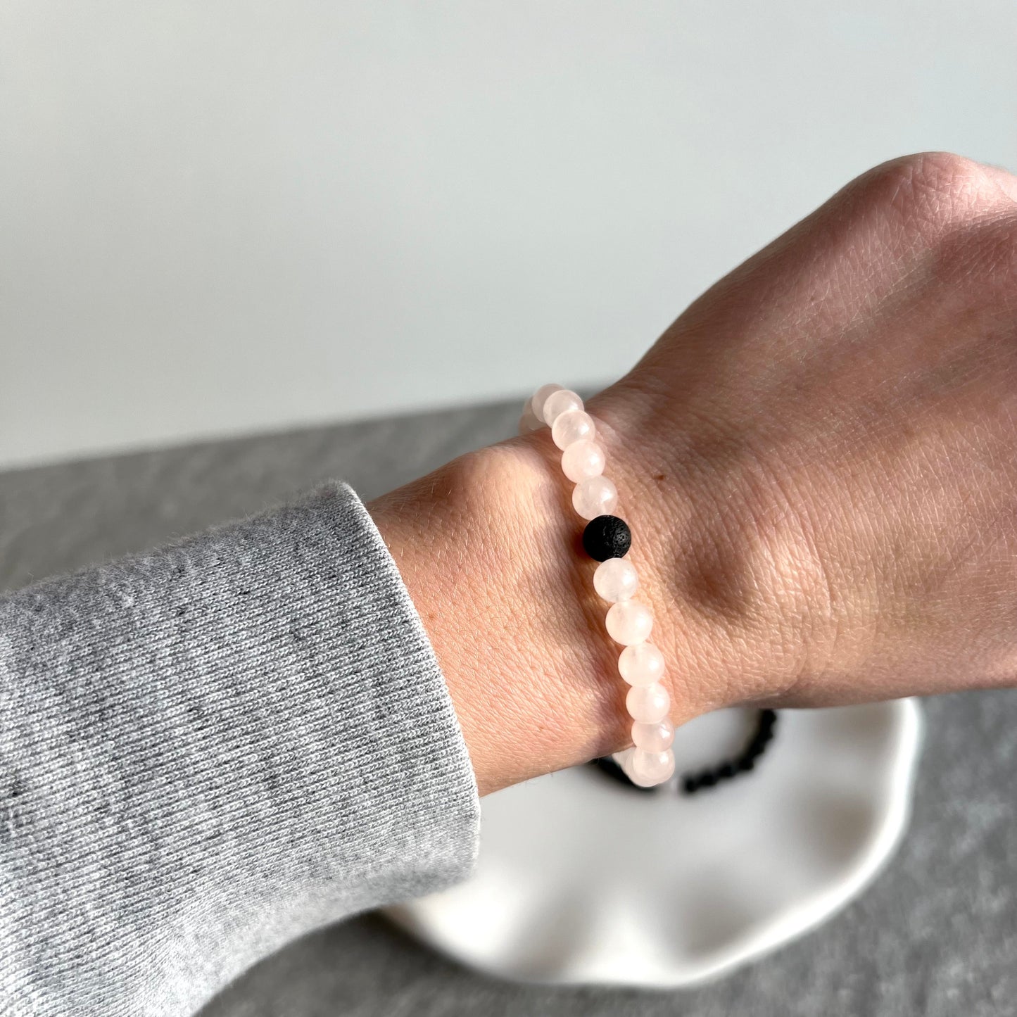 Partner-Armbandset aus 4mm Rosenquarz und Lavasteinperlen auf Tablett - Rosenquarzarmband getragen