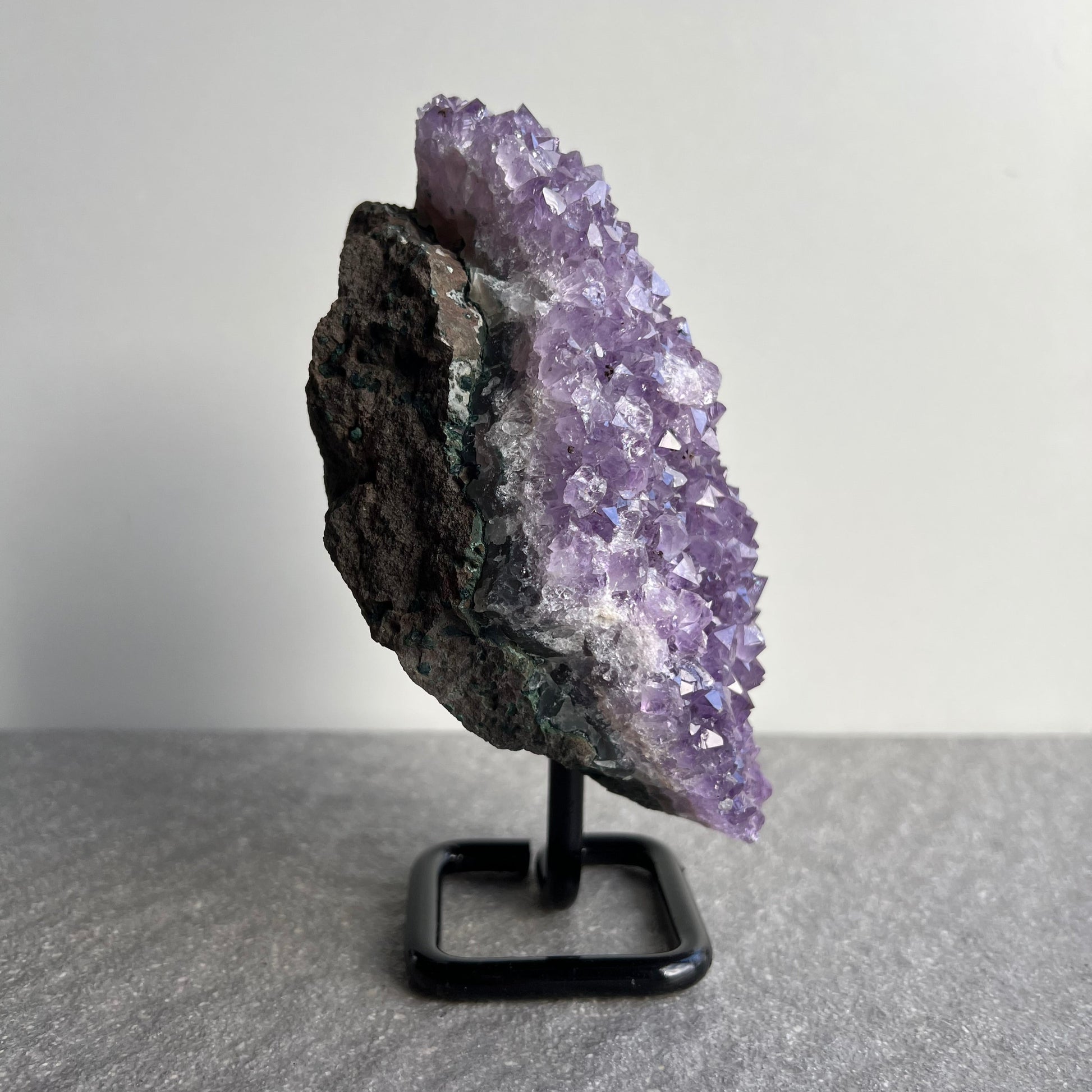 Wunderschöne dunkellila Amethyst Stufe auf schwarzem Metall-Ständer - viele kleine Kristalle - von der Seite 1
