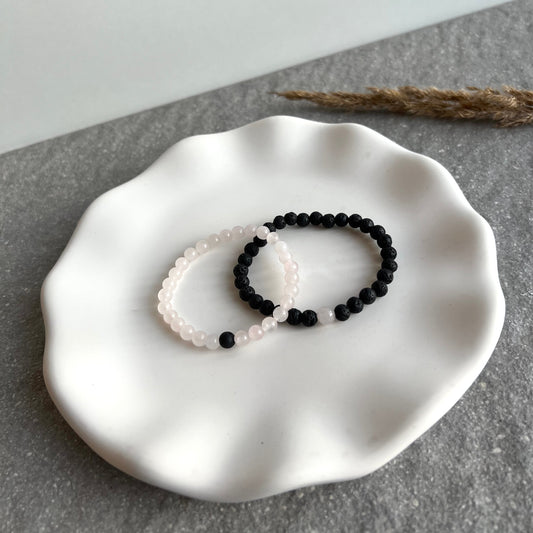 Partner-Armbandset aus 6mm Rosenquarz und Lavasteinperlen auf Tablett