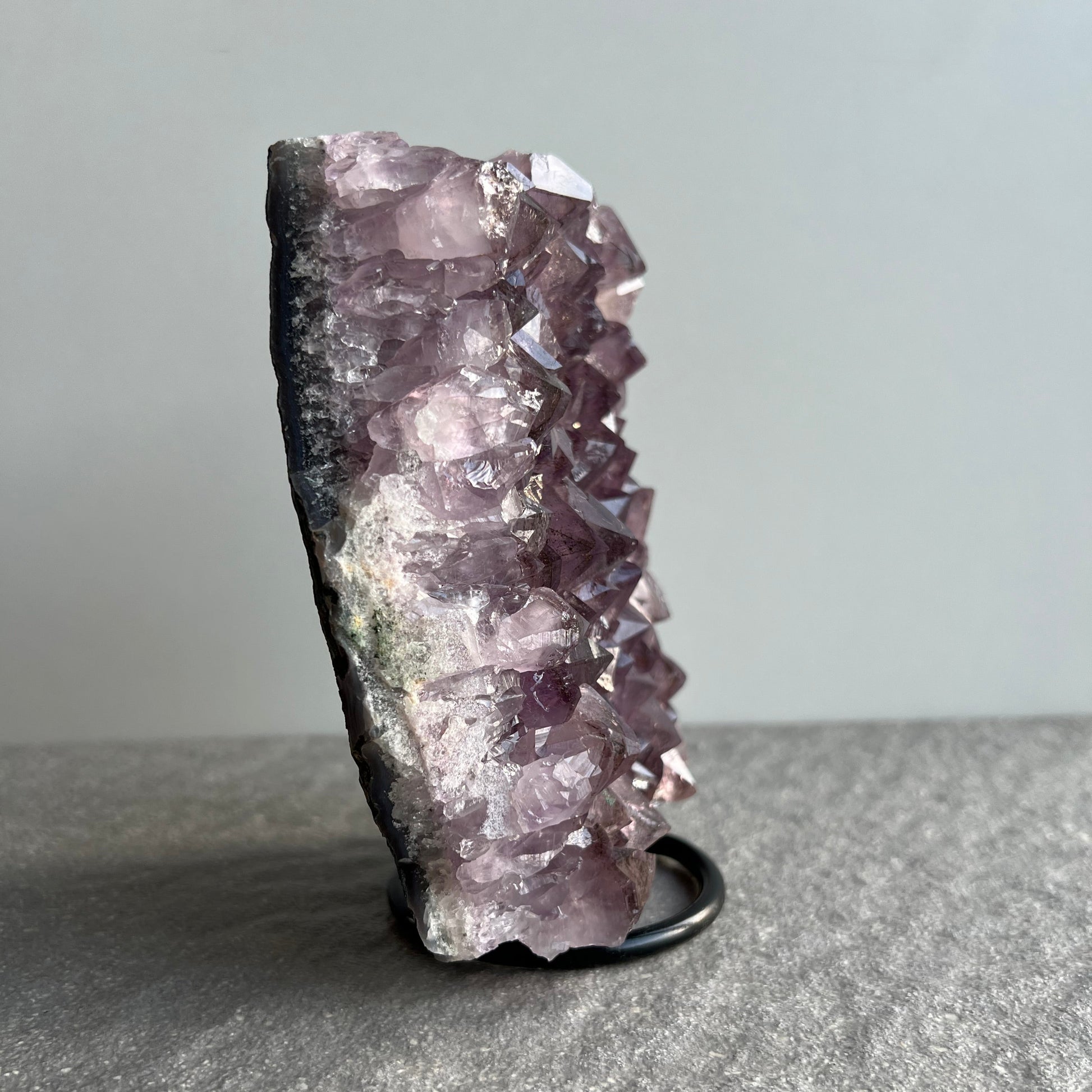 Wunderschöne dunkellila Amethyst Stufe auf schwarzem Metall-Ständer - viele große Kristalle - von der Seite 1