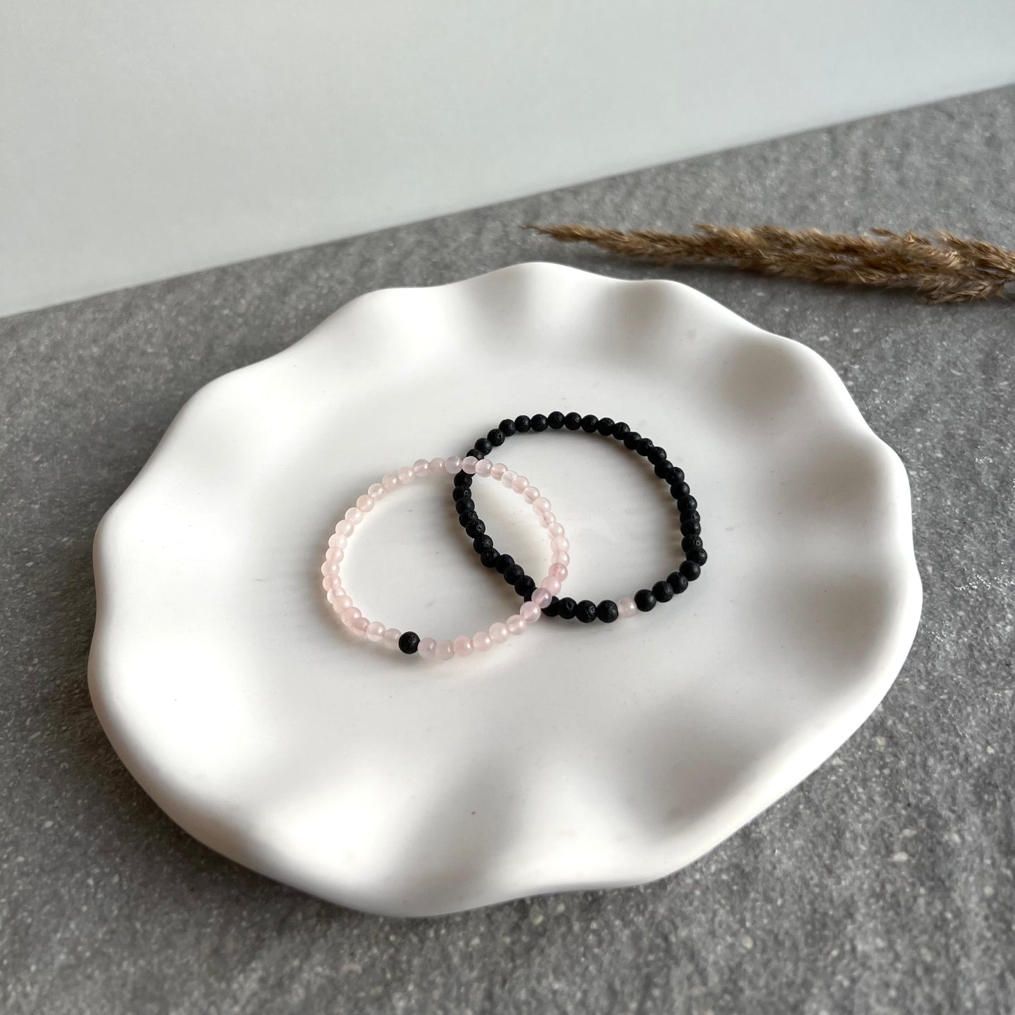 Partner-Armbandset aus 4mm Rosenquarz und Lavasteinperlen auf Tablett