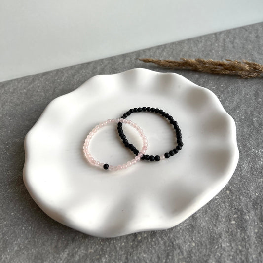 Partner-Armbandset aus 4mm Rosenquarz und Lavasteinperlen auf Tablett