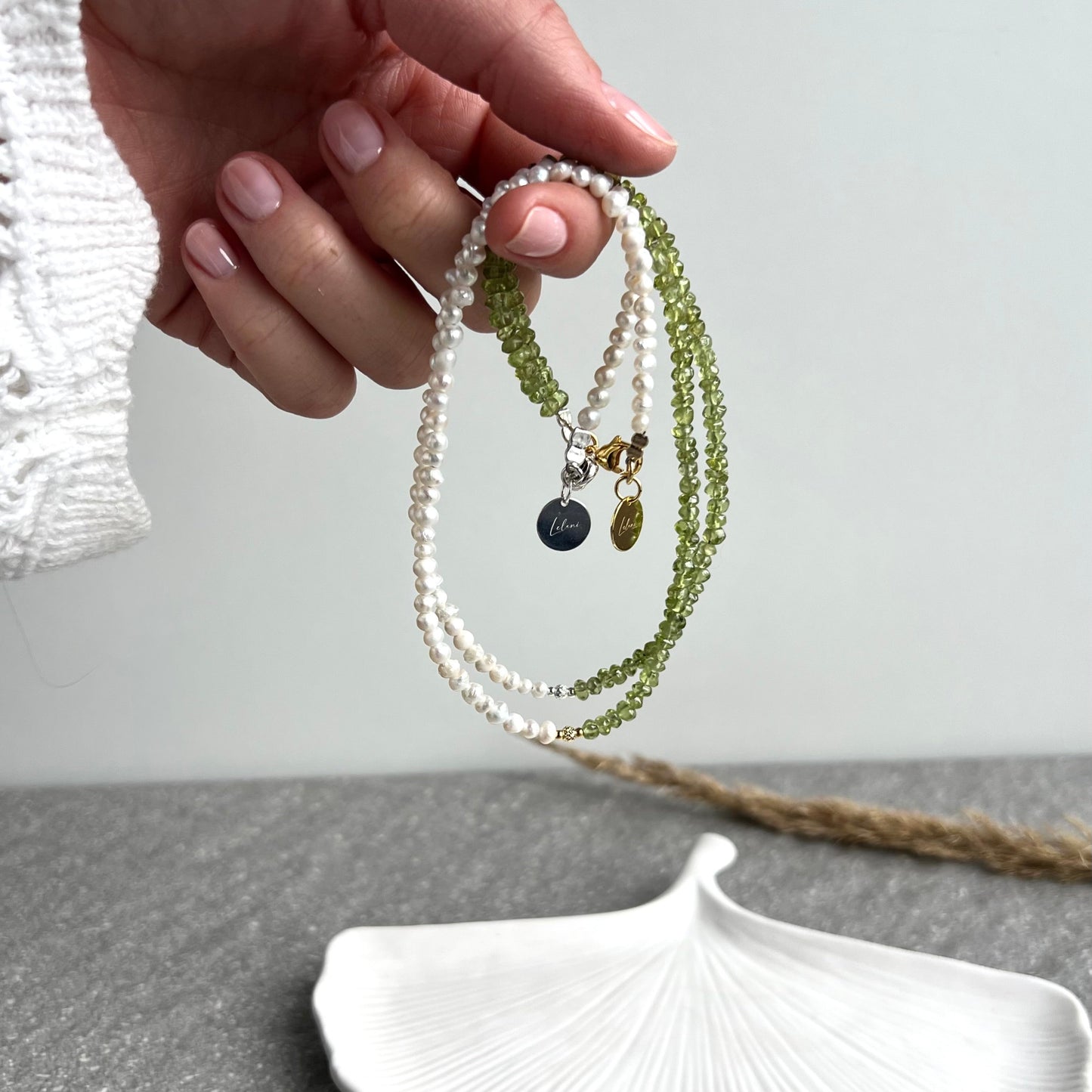 Choker aus Süßwasserperlen und Peridot und facettierter Perle aus 925 Silber oder 925 Silber vergoldet - Nahauafnahme - in der Hand gehalten