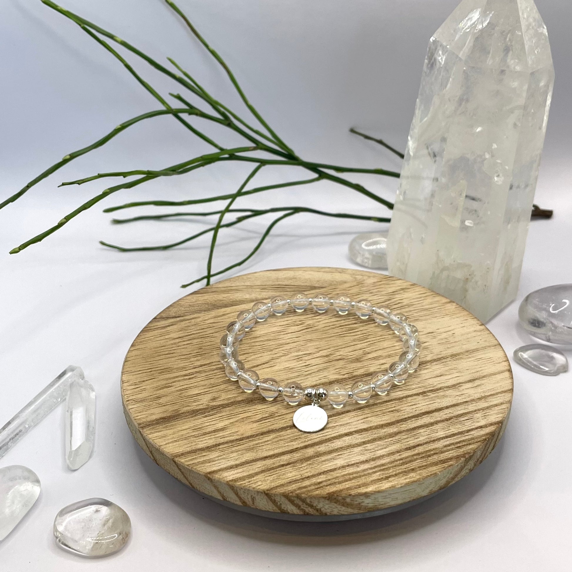 Bergkristallarmband mit Charm und Silberperlen auf Holztablett
