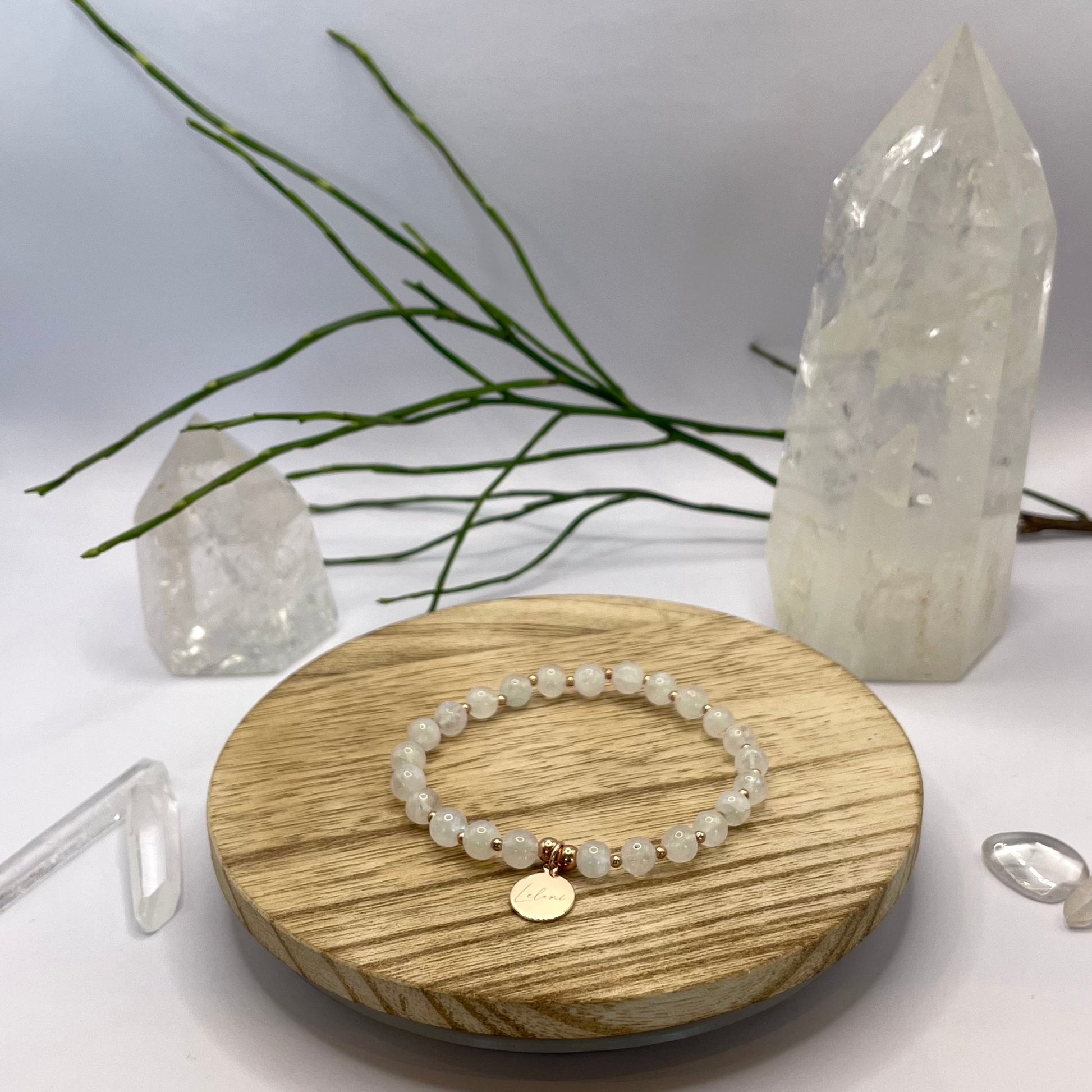 Regenbogenmondstein Armband mit Charm und Perlen auf Holztablett